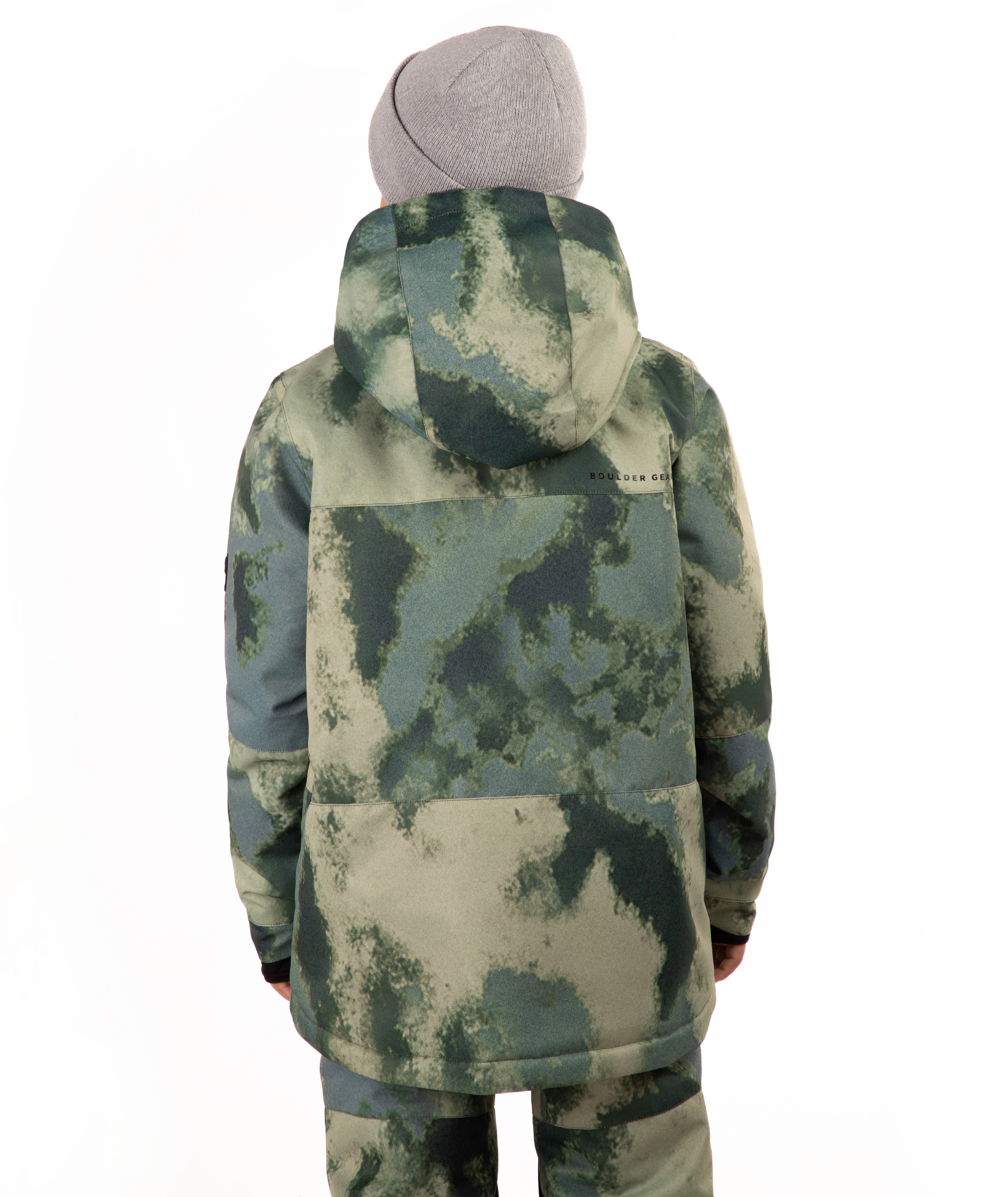 A child wearing a camouflage-patterned ski jacket and matching pants with a gray beanie, standing against a plain white background.