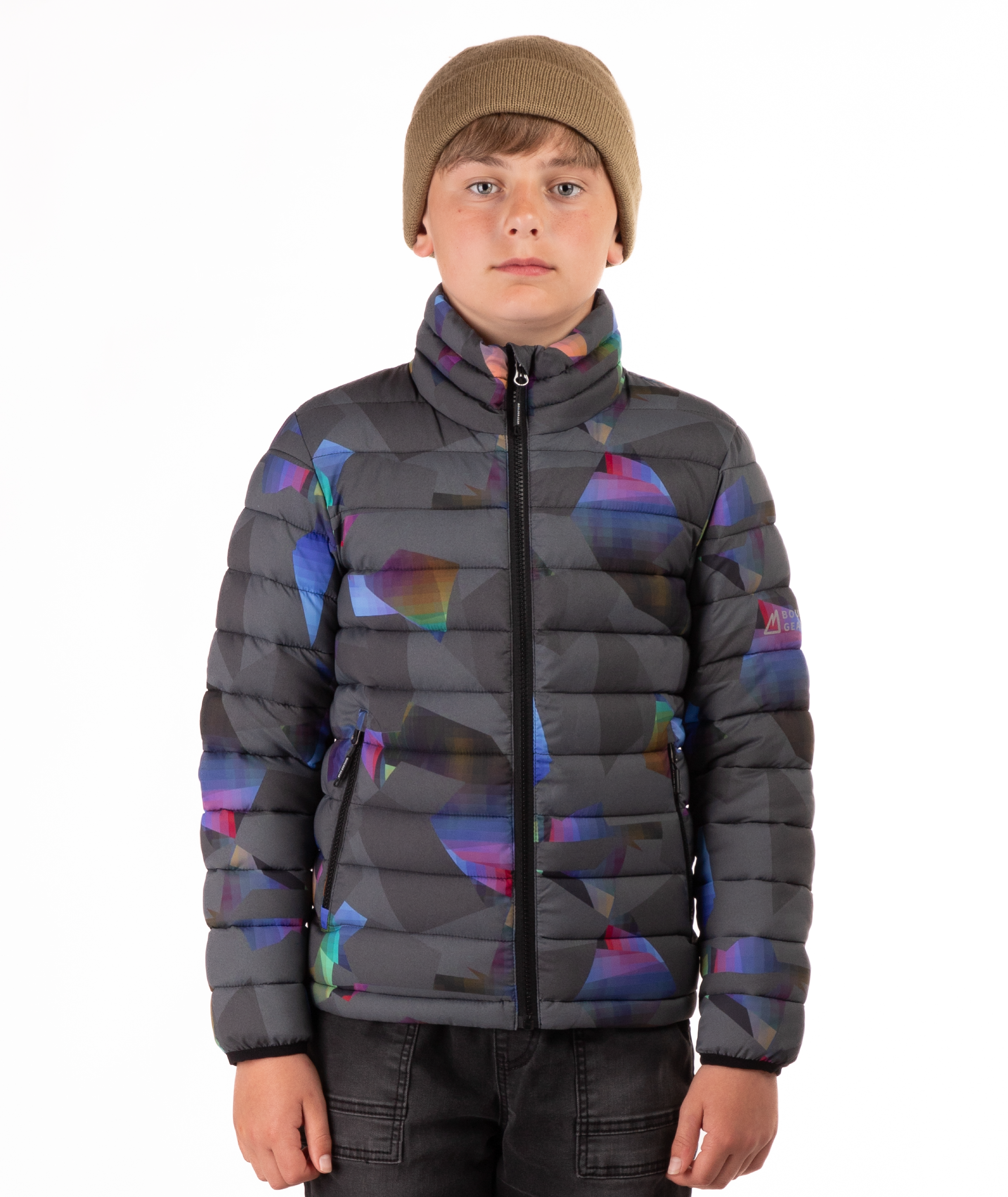 youth boy wearing a multi colored abstract patterned puffer jacket on a white background