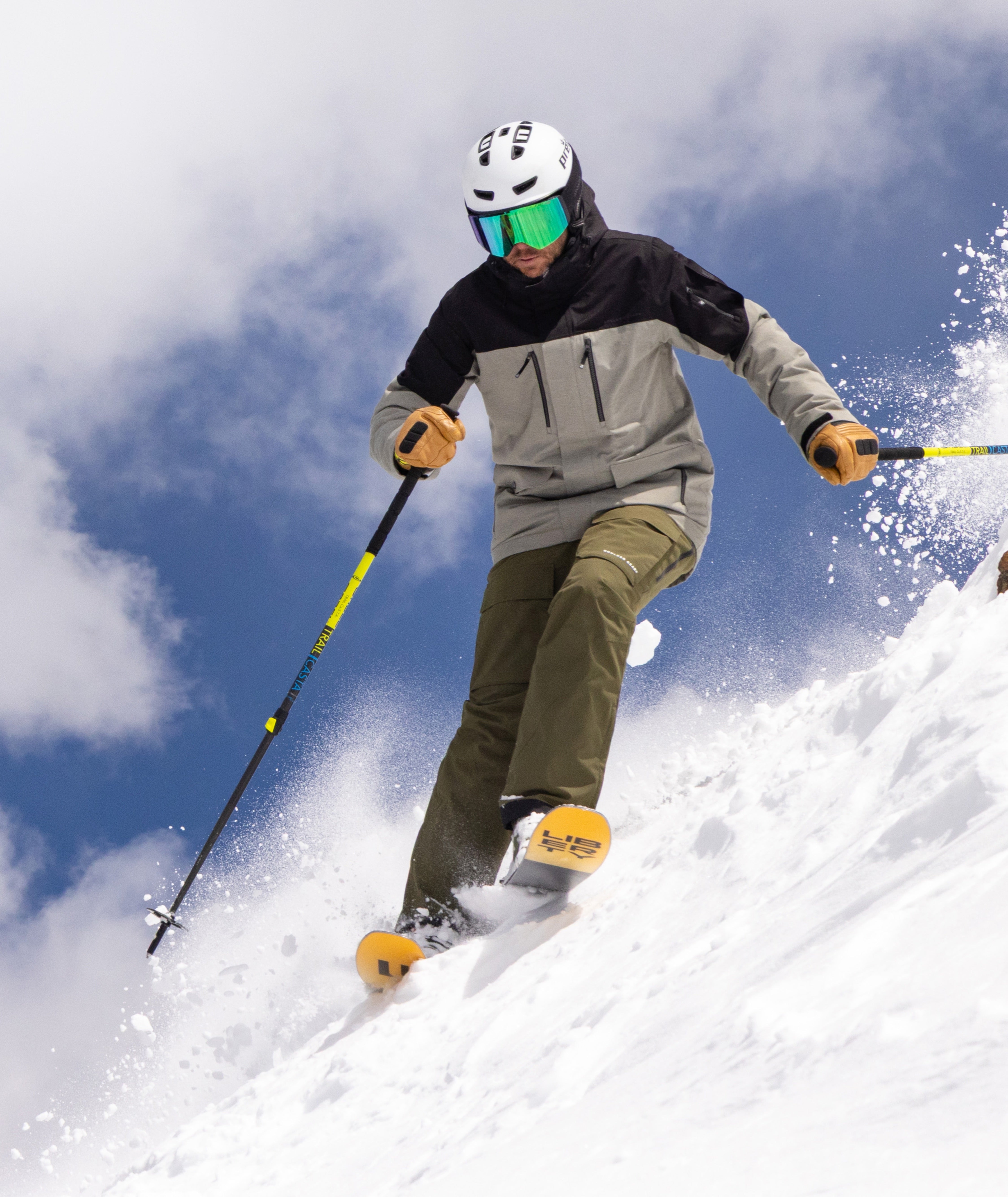 skier in action wearing a beige and black ski jacket