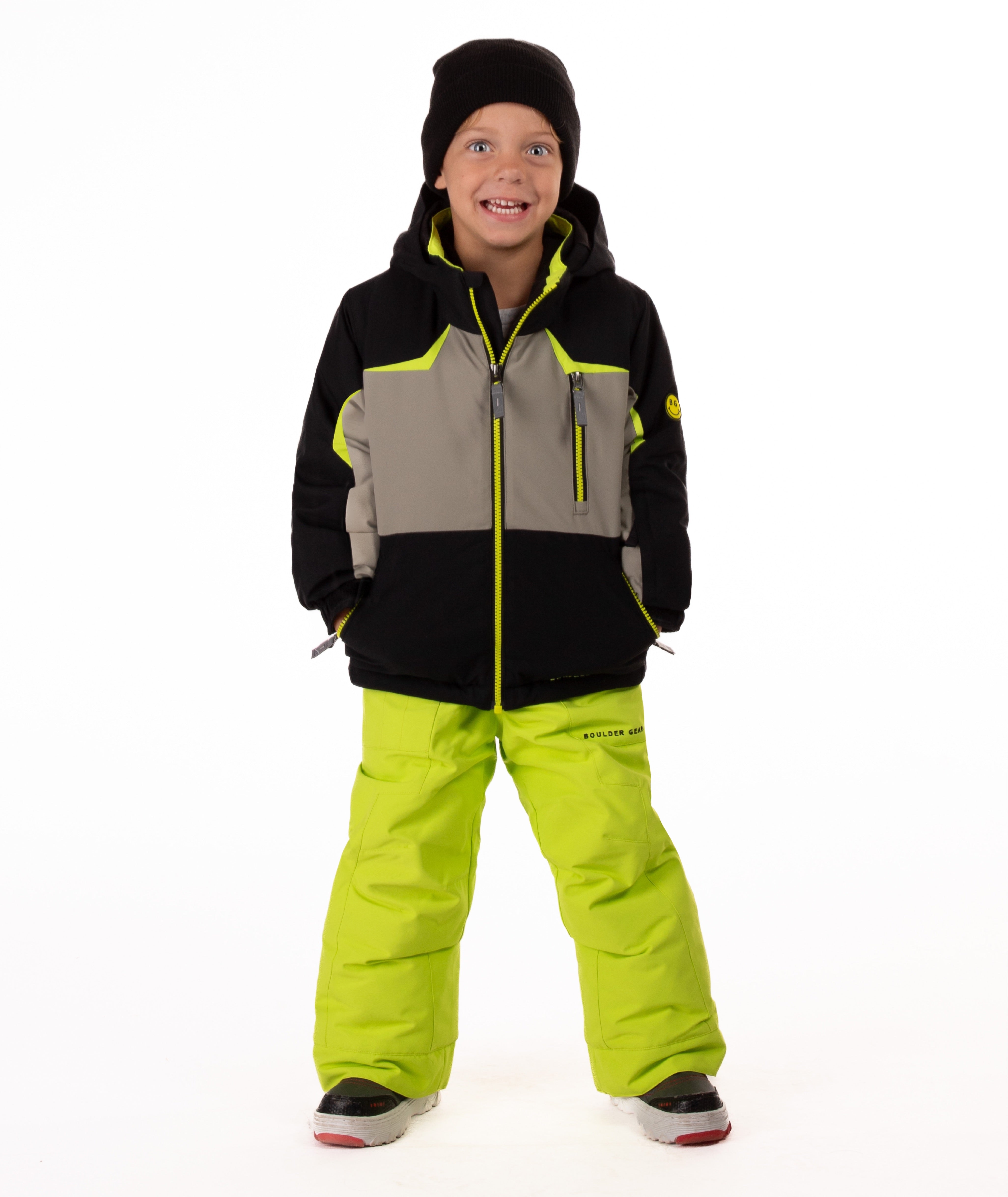 Child wearing an black and grey insulated winter jacket with bright lime trim