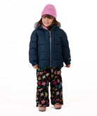 Child wearing a navy blue quilted puffy winter coat on a white background