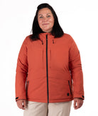 Woman wearing a rust colored winter jacket on a white background