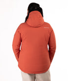 back of woman wearing a rust colored winter jacket on a white background