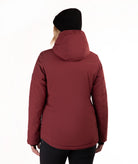 A woman viewed from the back wearing a dark red hooded puffer jacket, a black beanie, and black pants against a plain white background.