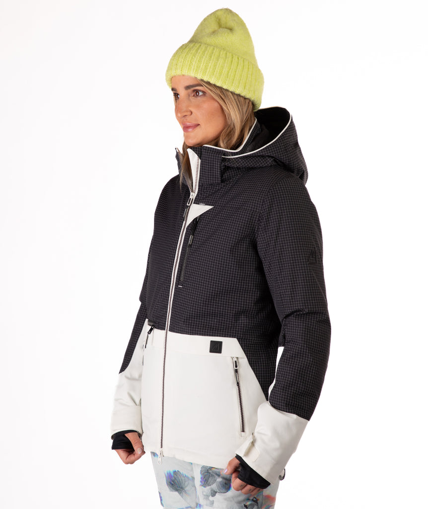 Woman wearing a two-tone black and white jacket a white background