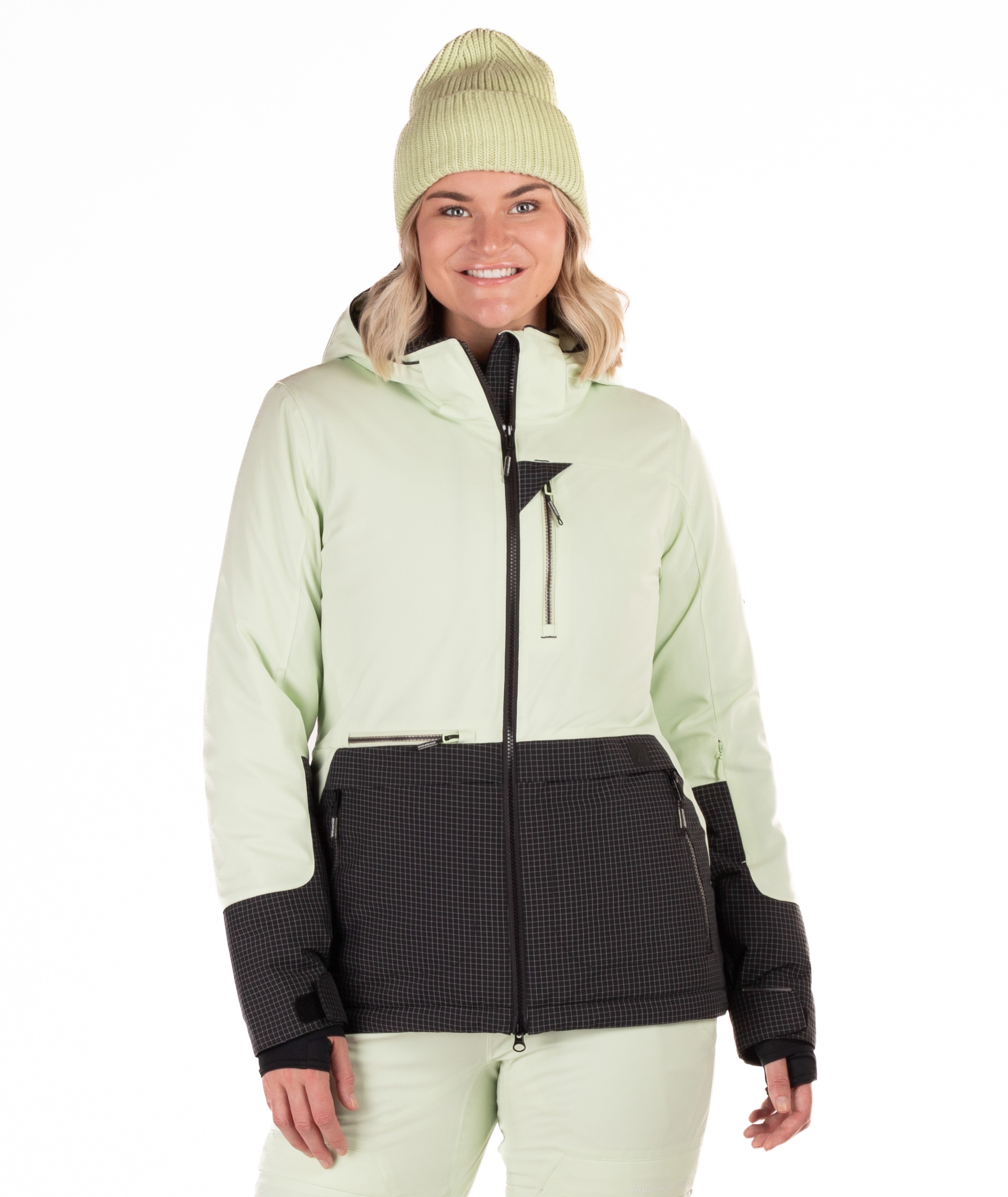 Woman wearing a two-tone light green and black checked jacket with a white background