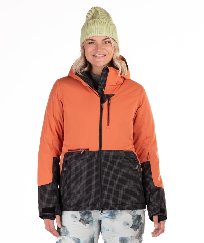 Woman wearing a rust orange and black checkered jacket two tone jacket with a white background