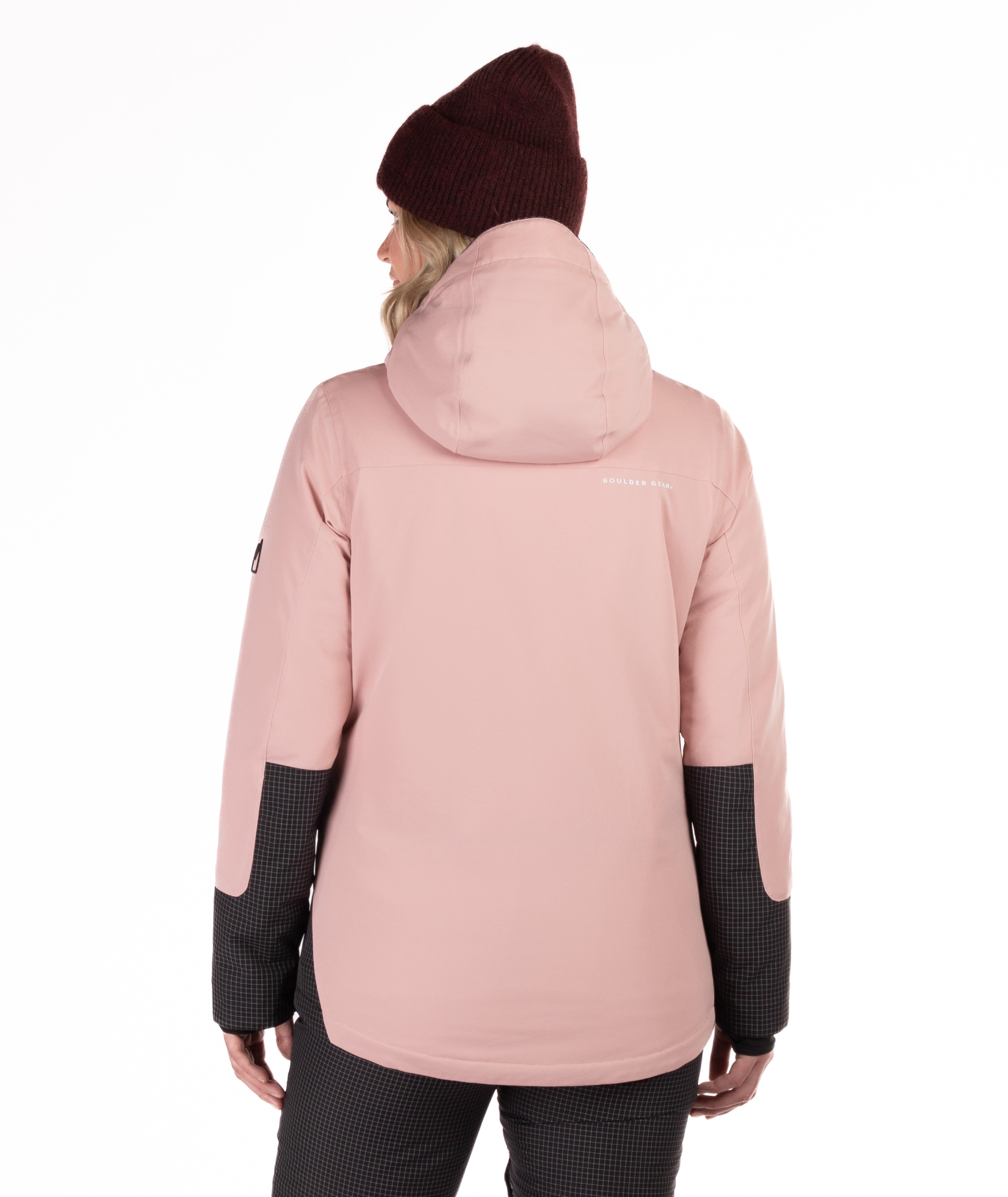 Person wearing a pink winter jacket with black check accents on a white background highlighting the back of the jacket and hood