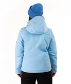 A woman wearing a light blue ski jacket and a matching knit beanie against a plain white studio background.