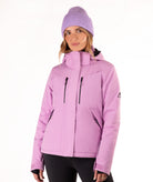 A woman wearing a light purple/lavender ski jacket and a matching knit beanie against a plain white studio background.