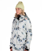 Person wearing a patterned snow jacket with black chest zippers on a white background