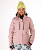 Woman wearing a pink jacket with black chest zippers on a white background