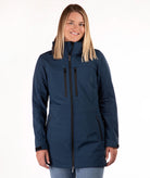 A woman modeling a navy blue hooded softshell jacket with black zippers, shown against a plain white studio background.