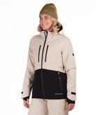 Woman wearing a beige and black jacket with a white background