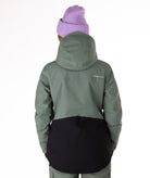 Person wearing a green and black jacket with a visible brand logo on a white background showing back view of jacket