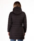 Woman wearing a black mid thigh length puffer coat on a white background