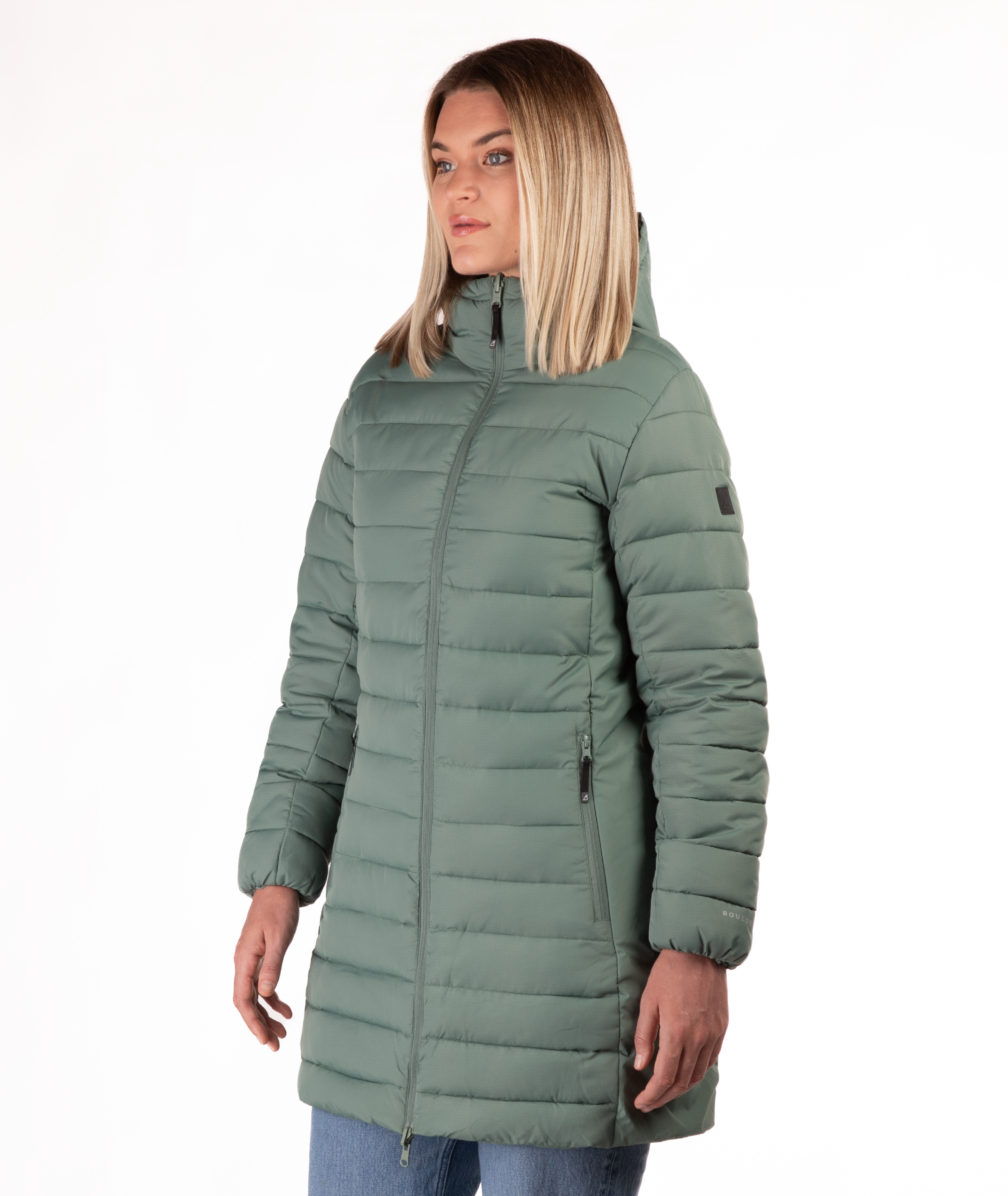 Woman wearing a green mid thigh length puffer coat on a white background