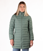 Woman wearing a green mid thigh length puffer coat on a white background