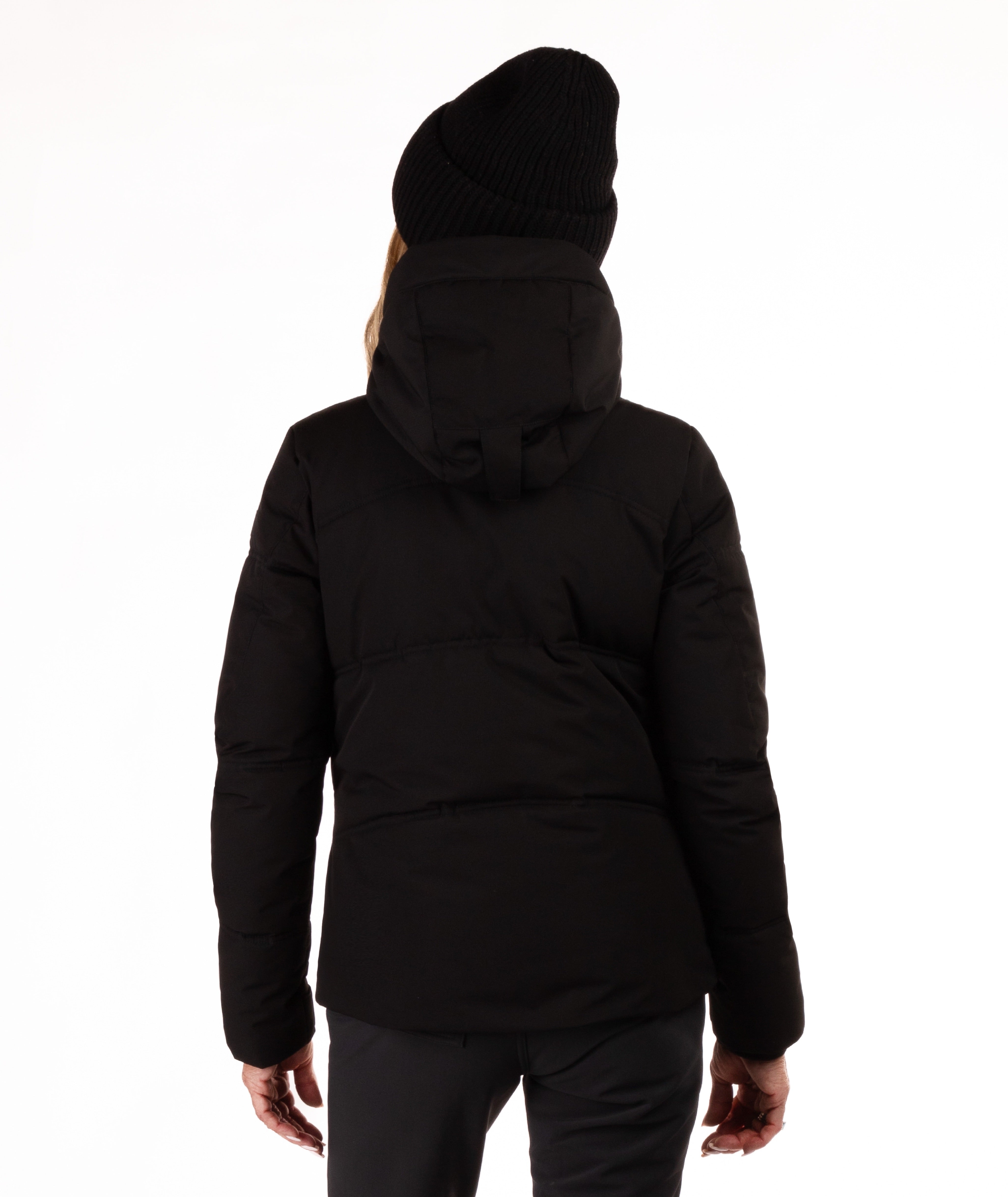 Woman wearing a black quilted winter jacket on a white background showing back of jacket and hood