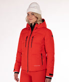 Woman wearing a red quilted winter jacket on a white background