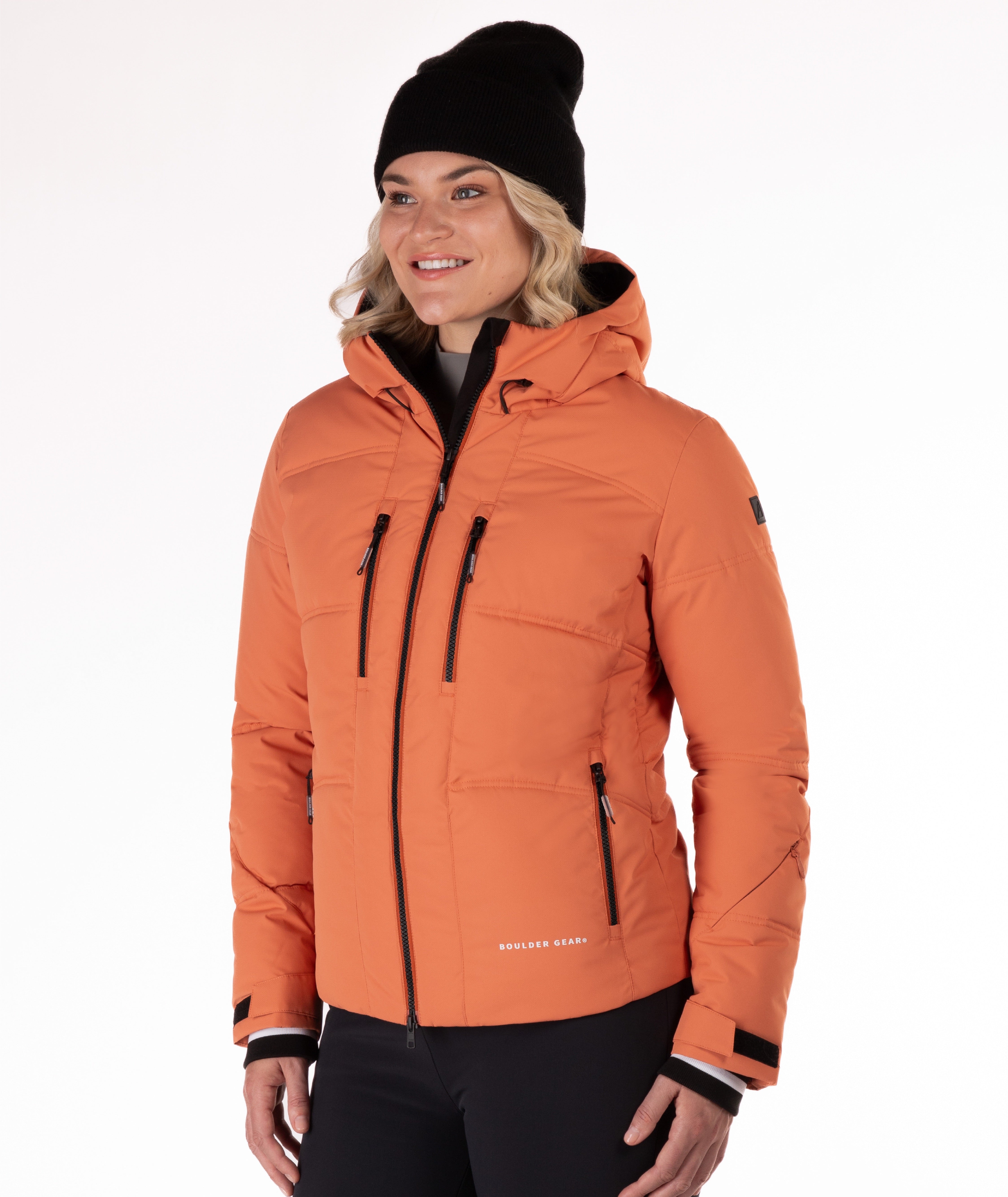 Woman wearing a coral quilted winter jacket on a white background