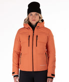 Woman wearing a coral quilted winter jacket on a white background