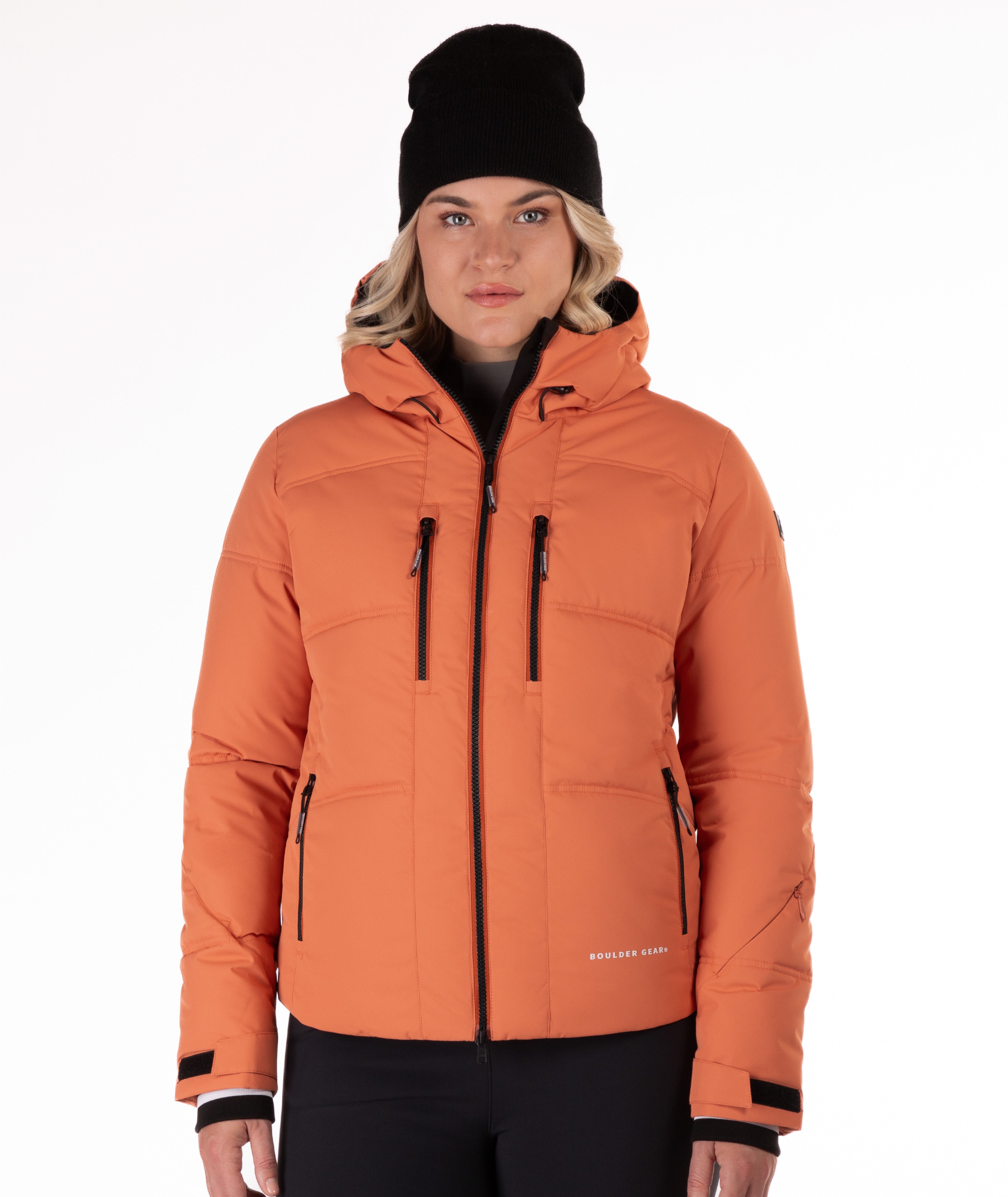Woman wearing a coral quilted winter jacket on a white background
