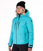 Woman wearing a bright blue quilted winter jacket on a white background