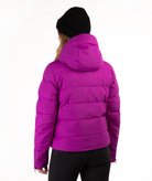 A person shown from the back wearing a bright magenta puffer jacket, a black knit beanie, and black pants against a plain white studio background.