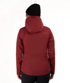 A person shown from the back wearing a hooded jacket in a deep burgundy red, a black beanie, and black pants against a plain white studio background.