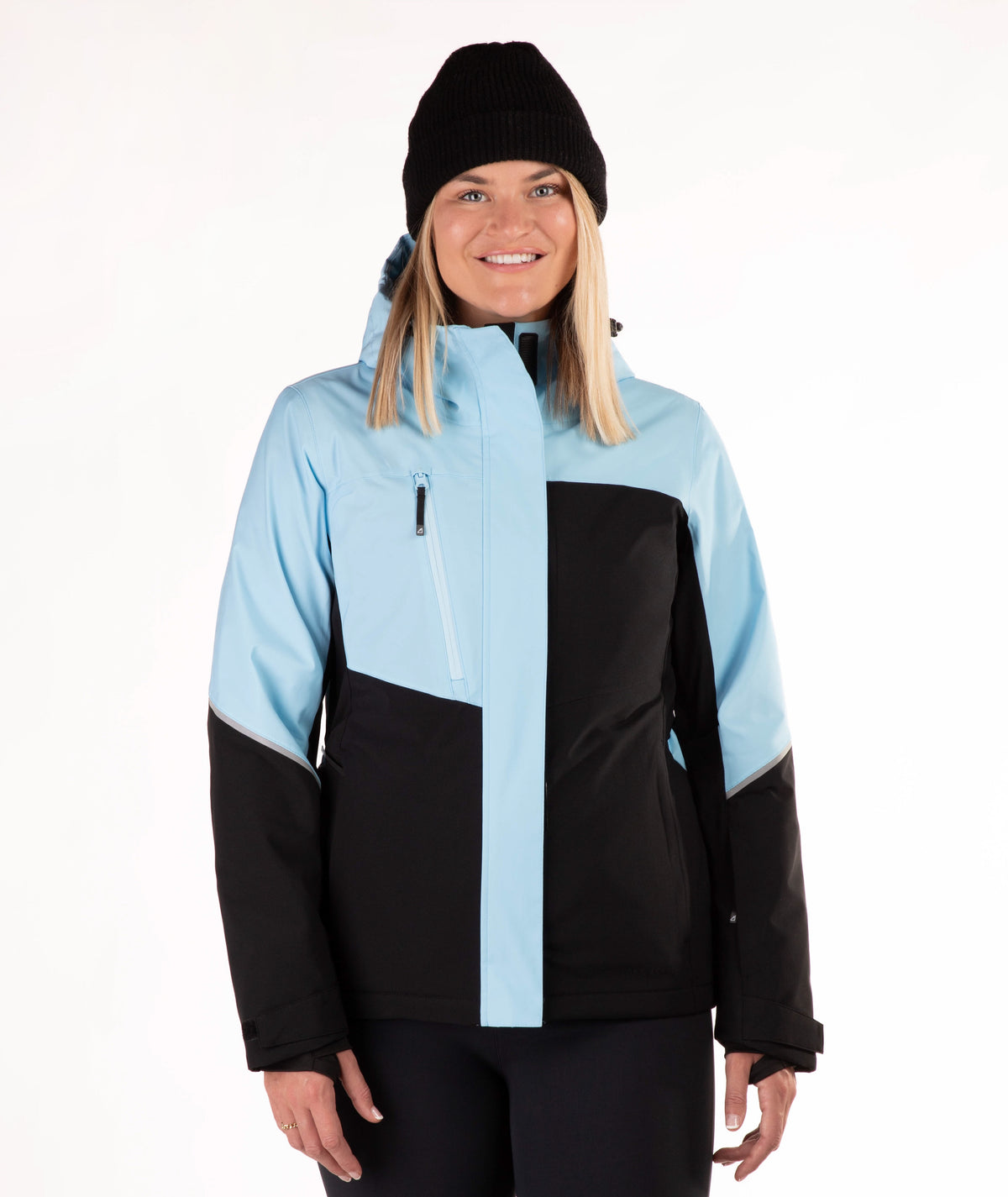A woman wearing a color-blocked ski jacket in light blue and black, paired with a black beanie, photographed against a plain white studio background.