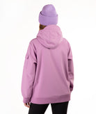 A person shown from the back wearing a lavender-purple hooded jacket and a matching ribbed knit beanie against a plain white studio background.
