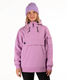 A woman wearing a light purple/lavender snowboard jacket with a half-zip hood and a matching knit beanie, photographed against a plain white studio background.