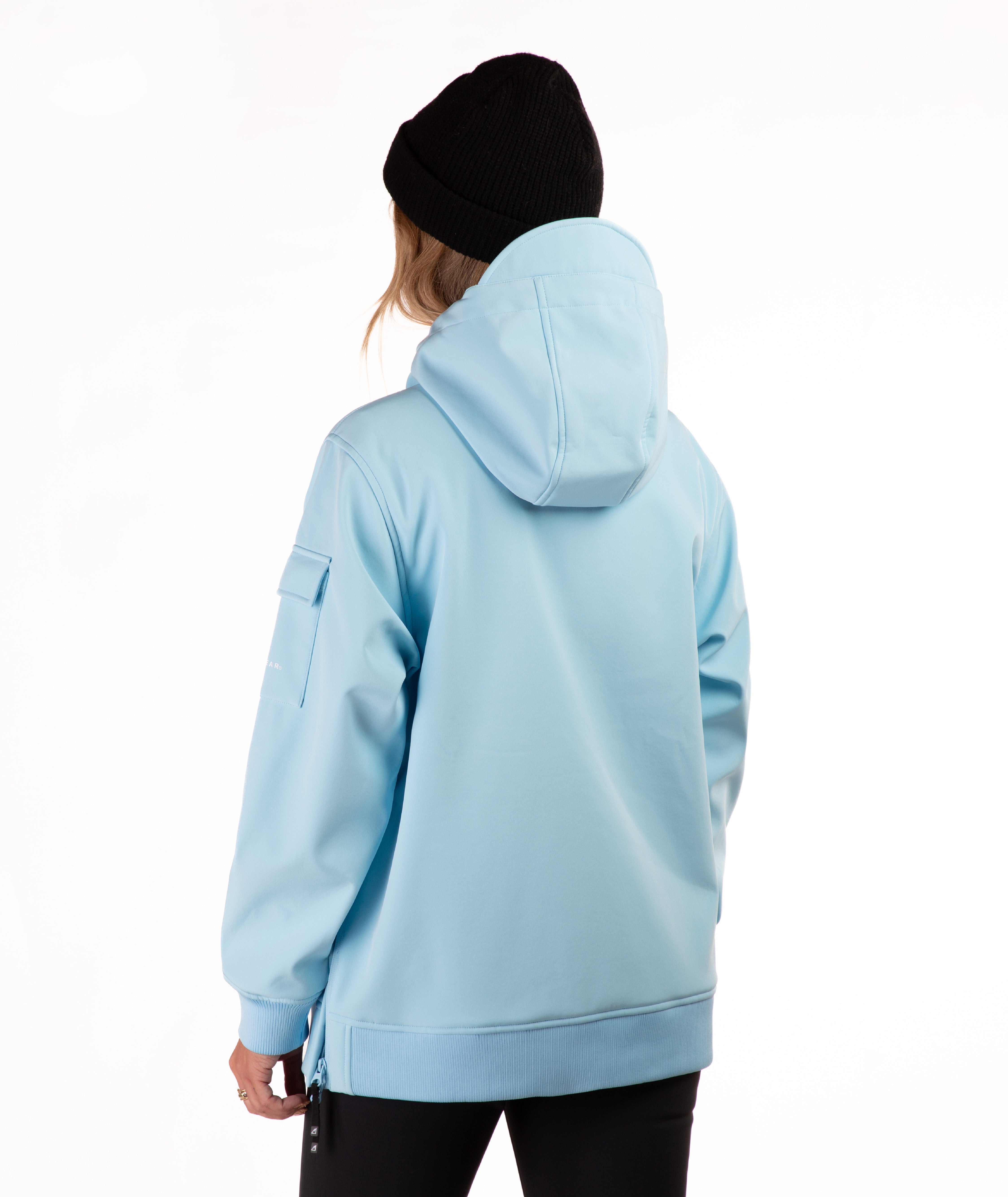 A person shown from the back wearing a light blue hooded jacket and a black beanie against a plain white studio background.