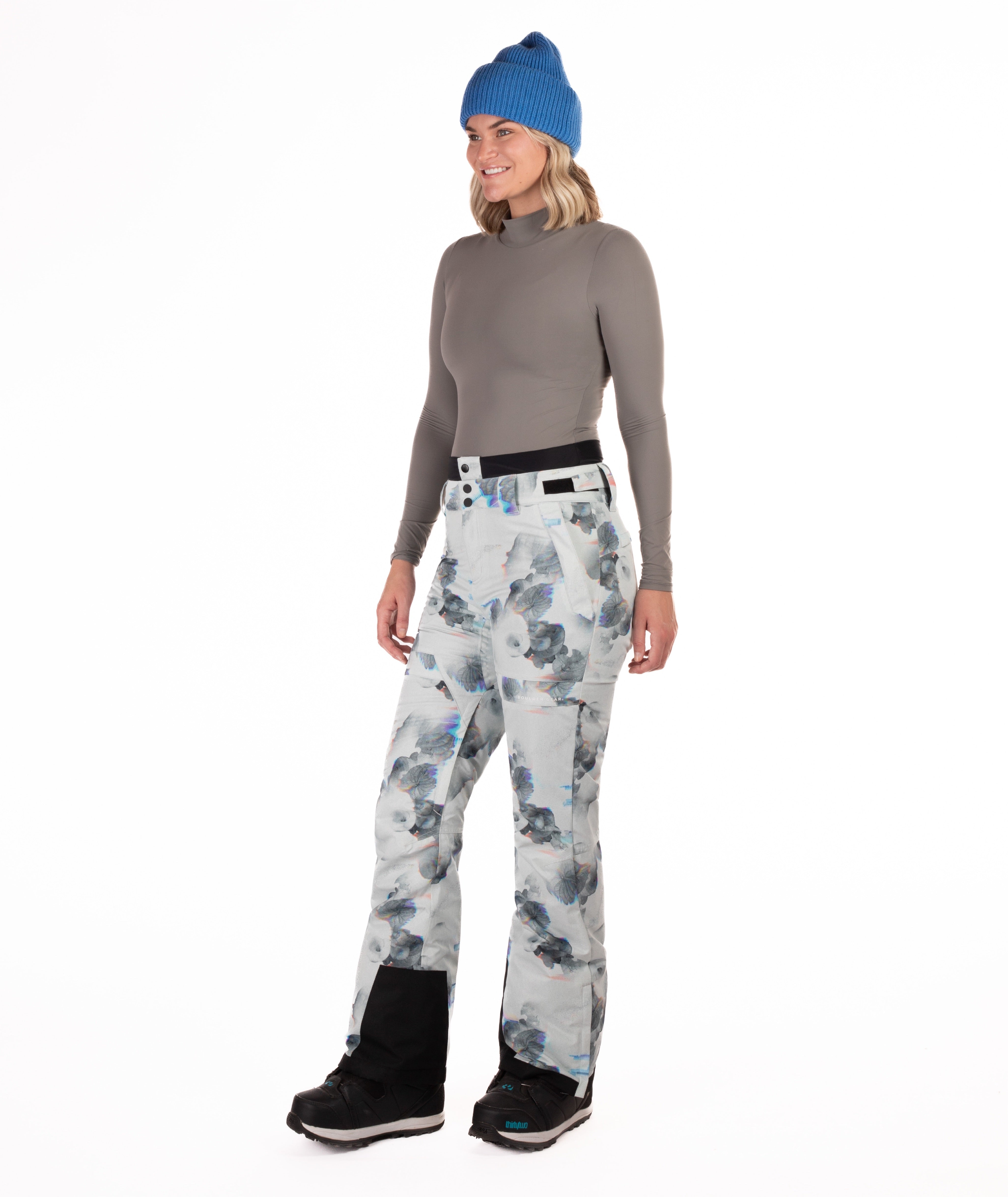 Person wearing floral patterned pants on a white background