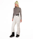 Person wearing off white colored pants on a white background