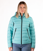 Woman wearing a light blue puffer jacket on a white background
