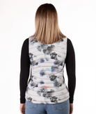 back of a woman wearing a flower patterned puffer vest over a black long-sleeve shirt on a white background
