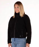 Woman wearing a black fleece jacket on a white background