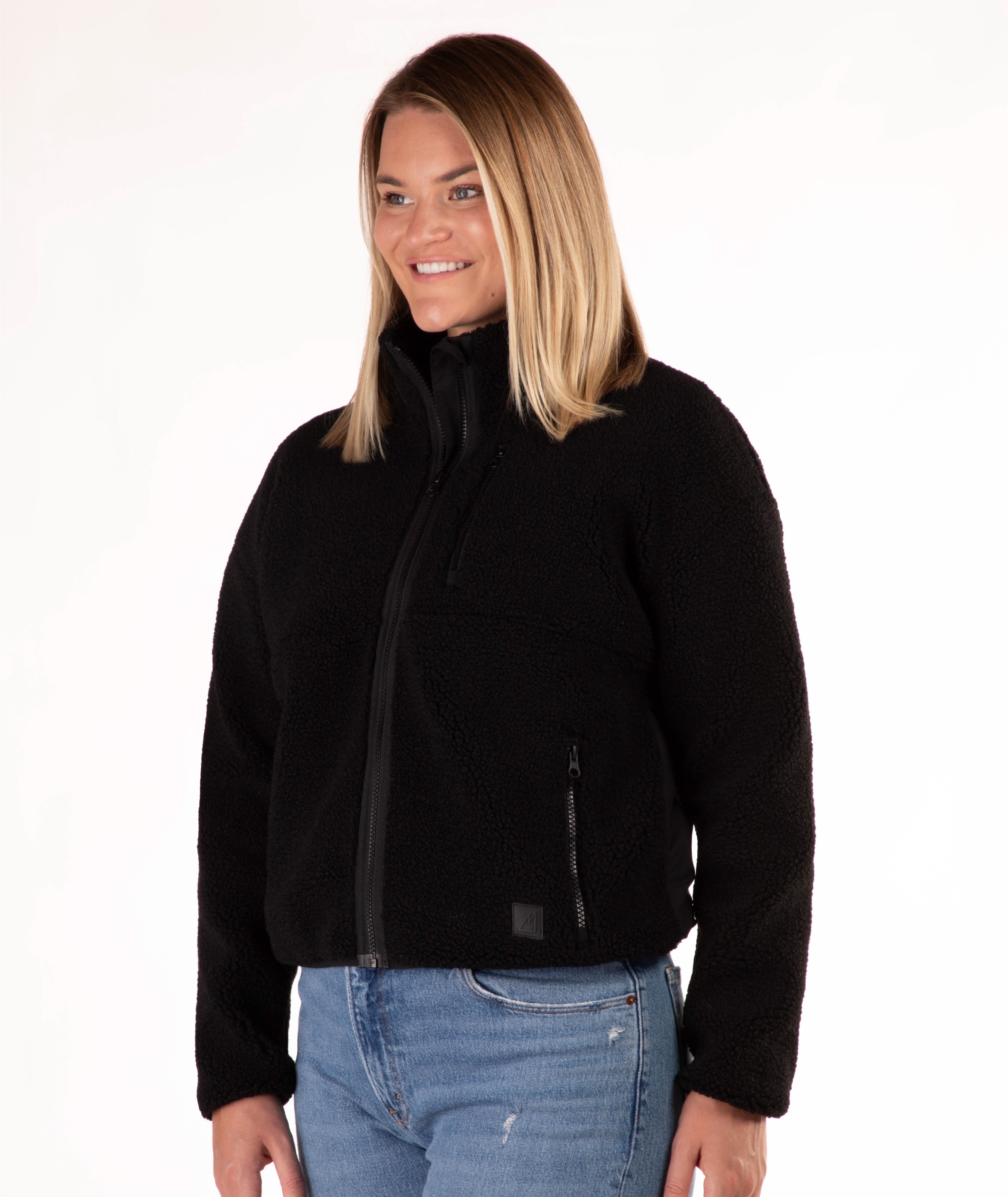Woman wearing a black fleece jacket on a white background