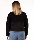 back of Woman wearing a black fleece jacket on a white background