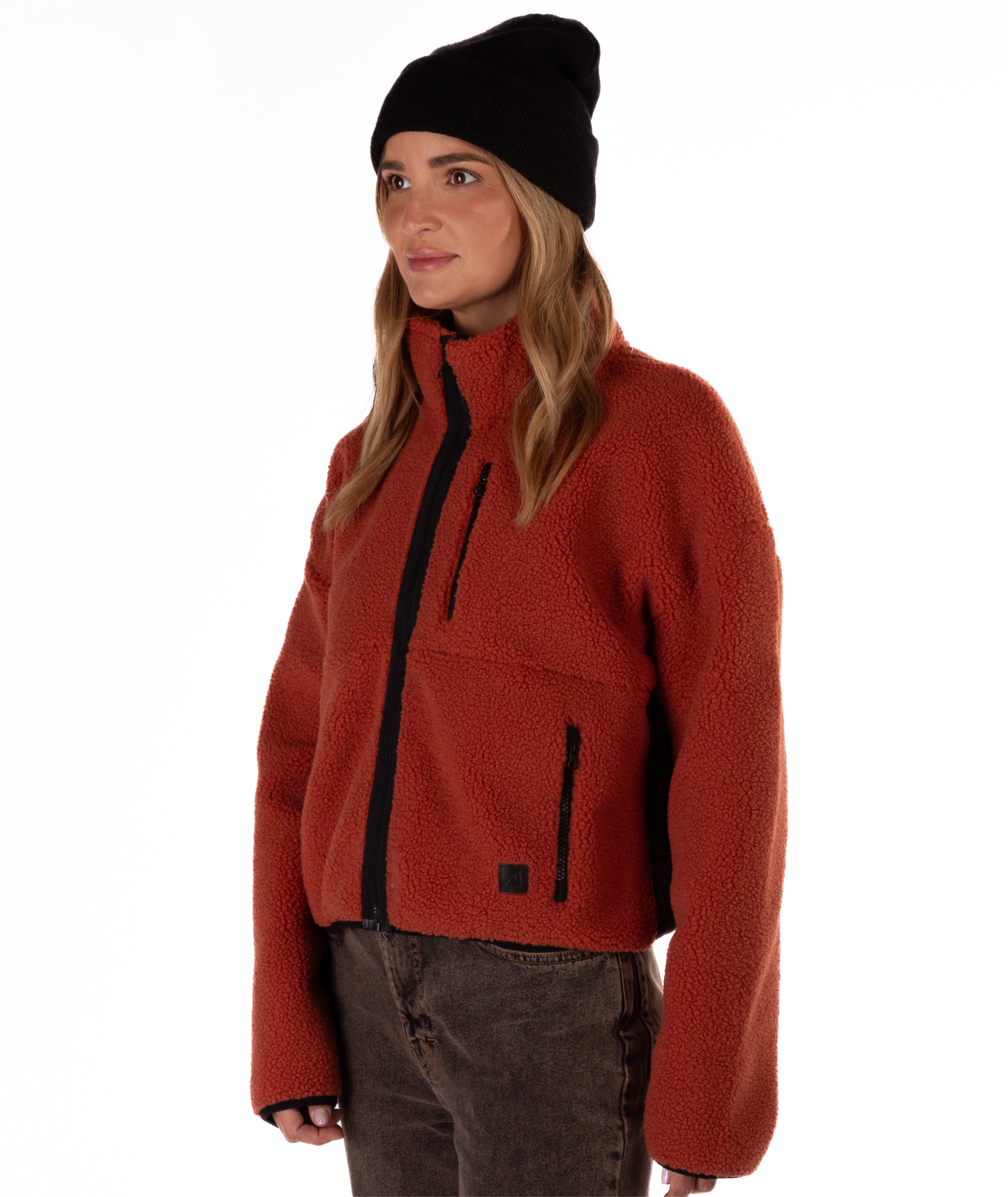 Person wearing a red fleece jacket with black zipper on a white background