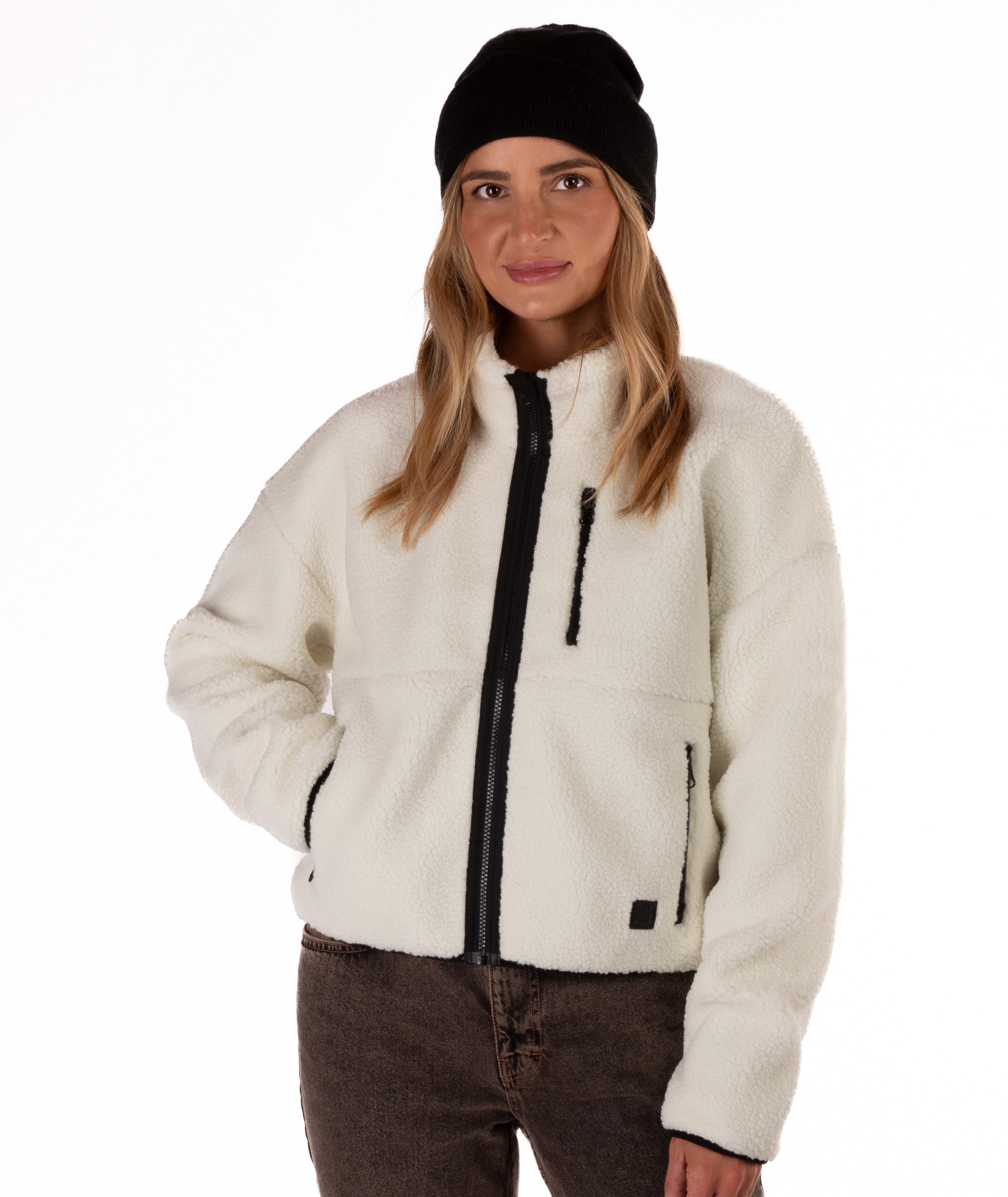 Person wearing a cream fleece jacket with black zipper on a white background