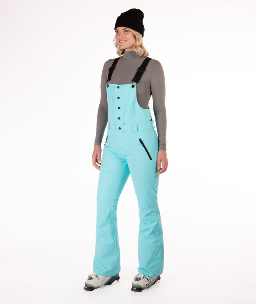 Person wearing a light blue snow bib overalls on a white background.