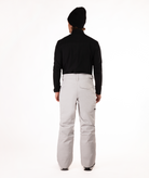 back of Person wearing a black top and light gray snow pants on a white background