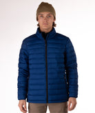 Man wearing a navy blue puffer jacket on a white background