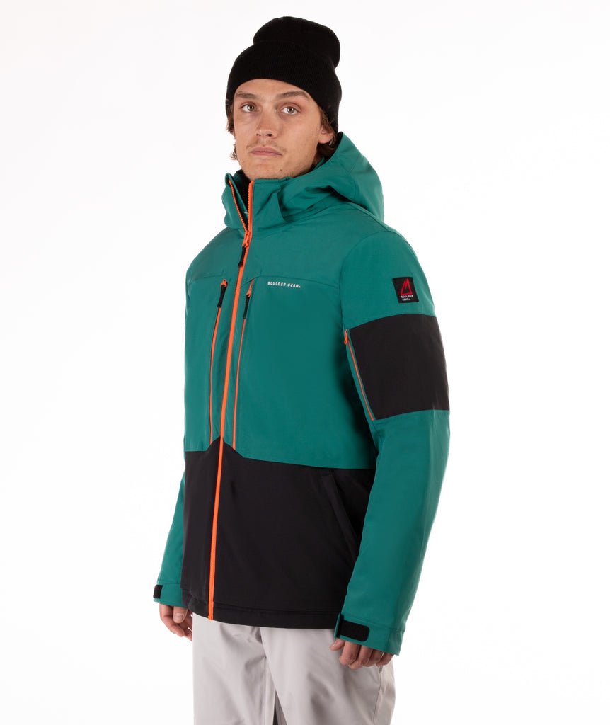 Person wearing a teal and black jacket with orange accents on a white background