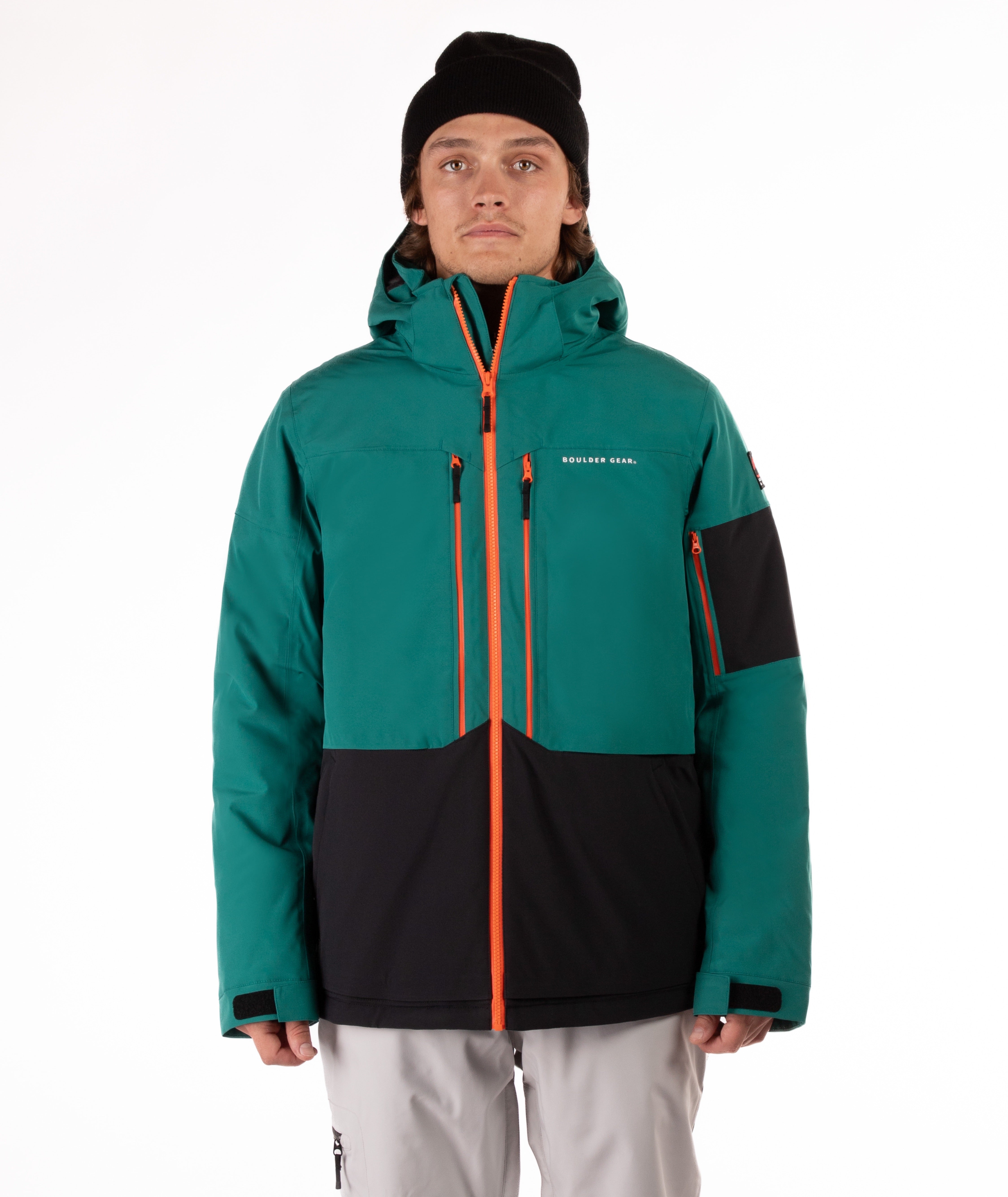 Person wearing a teal and black jacket with orange accents on a white background