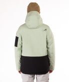 back of person wearing a light green and black jacket with hood on a white background