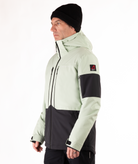 Person wearing a light green and black jacket on a white background